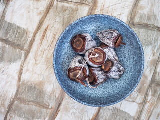 Dried persimmon in a deep ceramic plate on a light table