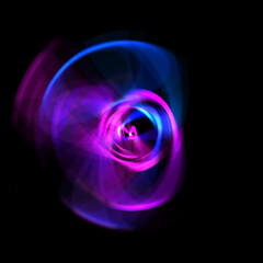 Spinning rays of light isolated on black background. Graphic 2D illustration of glowing colorful light particles in circular motion.