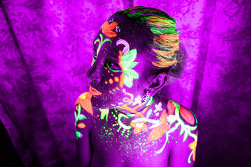 Mujer pintada glow in the dark, pintura de colores brillantes y artístico con luz ultravioleta