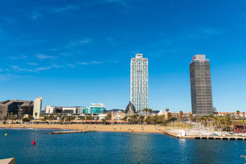 Fototapeta na wymiar BARCELONA, SPAIN, FEBRUARY 3, 2021: Famous towers of the port of Barcelona, the Mapfre Tower and the Hotel Arts. Sunny winter day. During the covid-19 pandemic. Barcelona Skyline.