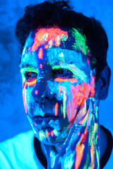 Hombre con pinturas glow in the dark, pintado de colores brillantes y artístico