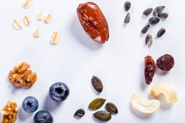 Seeds of sunflower, nuts, fruits and dried fruits on white background with copy space.