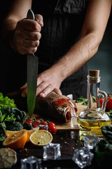 A man cook holds a fresh trout in his hands. Cooking fish.