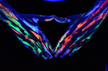 Hombre con pinturas glow in the dark, pintado de colores brillantes y artístico