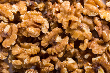 Background of big raw peeled walnuts situated arbitrarily.