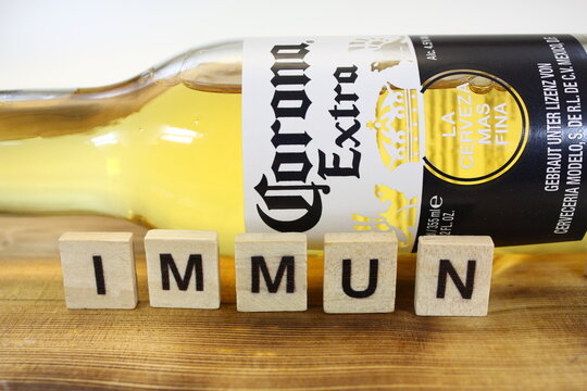 Corona Extra Flasche und Textbausteine mit dem Titel "IMMUN" auf einem Holzbrett