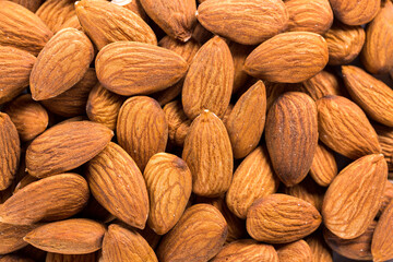 Background of big raw peeled almonds situated arbitrarily