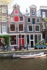Obraz premium Homes along a canal in Amsterdam, with canoes at the ready.