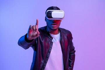 Excited Black Guy In VR Glasses And Jacket Enjoying Virtual Reality Experience