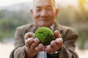 Asian old man showing earth on hand, ecology and environment sustainable concept.