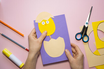 Naklejka premium Easter greeting card in egg shape. How to make children's paper craft. Step 9. Simple creative art project. Step by step instructions. Homemade easy paper applications. DIY concept.
