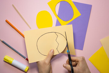 Naklejka premium Easter greeting card in egg shape. How to make children's paper craft. Step 3. Simple creative art project. Step by step instructions. Homemade easy paper applications. DIY concept.