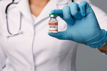 Obraz premium Vaccination Concept. Unrecognizable female doctor holding ampule with COVID-19 coronavirus vaccine