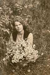 Latvia - CIRCA 1930s: Young female portrait in garden. Women with flowers. Vintage Carte de Viste Edwardian era photo