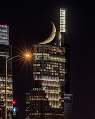 Crescent moon setting behind Comcast Technology Center in Philadelphia 