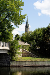 Tay River enbankment during summer in Perth, Ontario. Church steeple can be seen in background. River view, with stairs, trees and blue sky with clouds