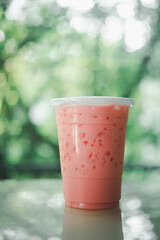 Iced pink fresh milk in plastic cup