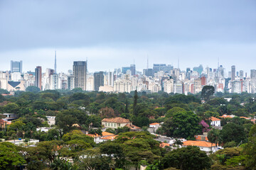 Fototapeta na wymiar Aerial view of São Paulo city skyline, park, houses and trees and buildings in the background on a cloudy summer day. Concept of urban, city, architecture, cityscape, metropolis, business, tourism.