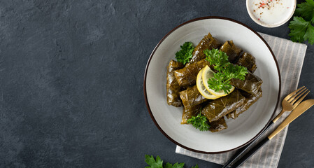Dolma on a dark background. Traditional Caucasian, Turkish and Greek cuisine, top view, place for text