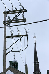 un poteau électrique et le clocher d'une église