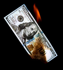 One Hundred Dollars are burning on a black