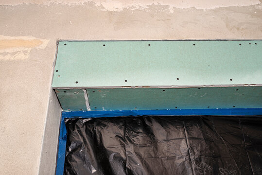 Installation for external roller shutters made of plasterboard inside the building, windows are covered with protective foil.