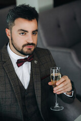 Portrait of handsome man in business suit holds glass .