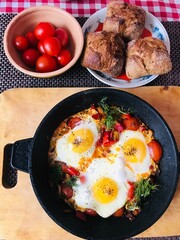 Shakshouka Scrambled eggs with buns perfect breakfast. Shakshuka is dish of eggs fried in sauce of tomatoes, hot peppers, onions and spices.