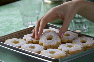 beautiful female hand taking a biscuits from a group