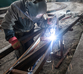 A worker welds metal for a canopy.