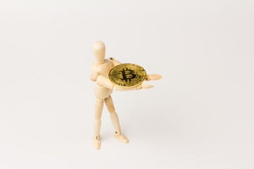 Wooden mannequin holding bitcoin coin, Digital Money and Bitcoine Concept.