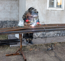 A worker welds metal for a canopy.