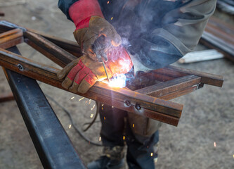 A worker welds metal for a canopy.