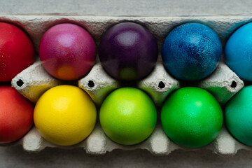 Colored Easter eggs in carton box, closeup view