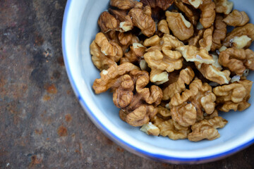 Walnuts harvest on vintage metal background. Walnut kernels from village garden. Organic autumn nuts harvest.