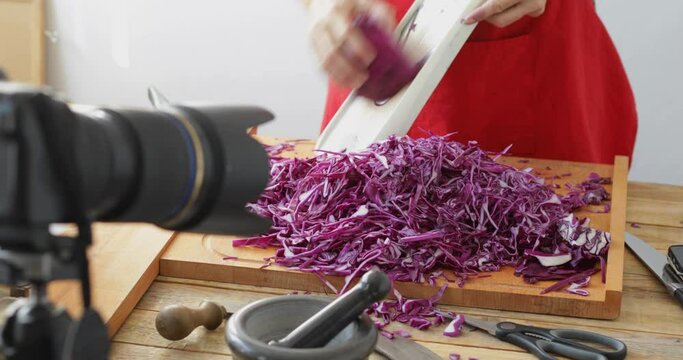 Food vlog recording, Red cabbage cut into thin slices using kitchen mandoline slicer, sauerkraut making process, close up