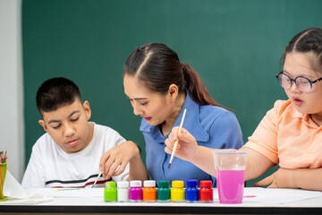 Asian disability boy learning color Painting in classroom with Autism girl in special school with female teacher.