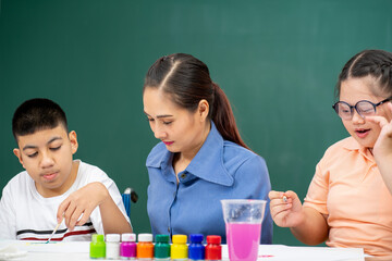 Asian disability boy learning color Painting in classroom with Autism girl in special school with female teacher.