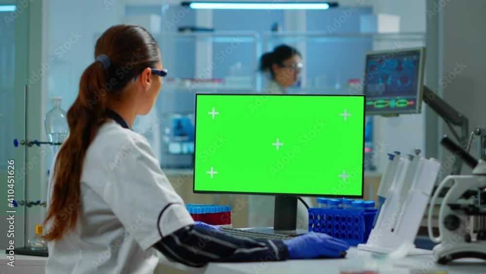 Aufkleber woman researcher typing at computer with green screen mockup display, template in applied science la