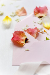 rosa und gelbe Blüten auf einem rosa Kuvert mit Seidenband - Hochzeitseinladung, Papeterie, Deko