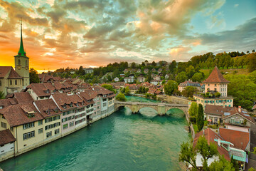 Fototapeta na wymiar Scenic skyline of Bern, capital of Switzerland and canton of same name at sunset. Aerial view of old city center, UNESCO World Heritage Site, Nydegg Church and Untertorbrucke bridge above river Aare.