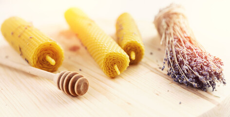 Obraz na płótnie Canvas Banner Yellow candles made of beeswax with honey and lavender scent