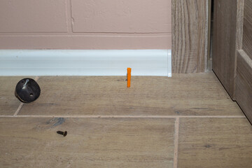 Installing a metal door stop. Preventing wall damage