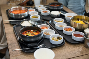 Various of Korean food with spicy soup, kimchi, noodles and vegetable pickle on tray