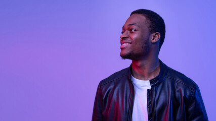 Handsome African American Guy In Leather Jacket Under Neon Lighting Looking Aside