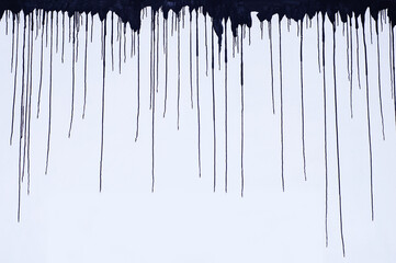 Black smudges of paint on top of white wall. Gloomy background.