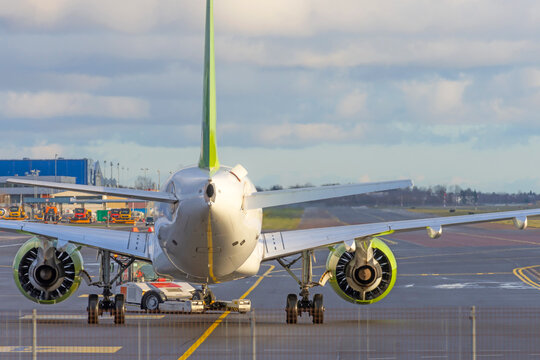 The plane pushes the tow tractor before starting the engines and taxiing, rear view.