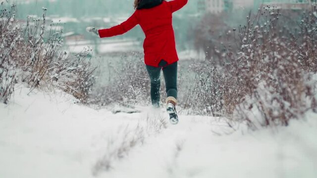 In winter, a young girl slips in her shoes on the snow in a snowfall and could not resist and fell to the ground hitting her head and shoulders hard, from pain and injuries she twisted to the side.