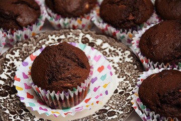 Chocolate cup cakes, colorfull hearts on liners, brown plate, Valentine's  day celebration