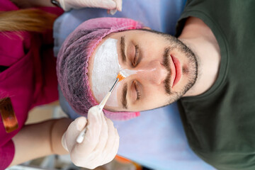 Procedure on the forehead. Man at cosmetologist. Mesotherapy, plasmolifting. Botox injections. Closeup.